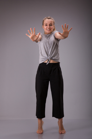 Prohibition symbol. Smyling female shows stop sign talk to hand gesture.の写真素材