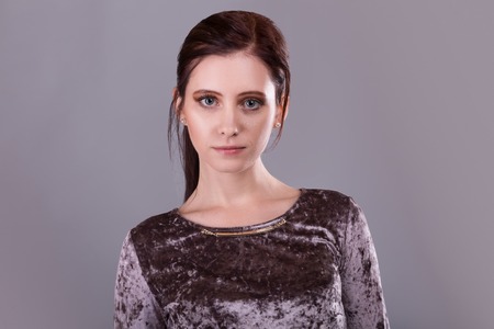 Beauty portrait of a gorgeous young brunette woman over gray backgroundの写真素材