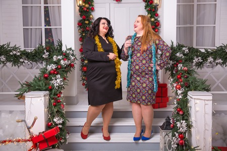 Party and celebration. Winter holiday. Christmas plus size woman New year girls staying on porch. sexy plus size womanの写真素材