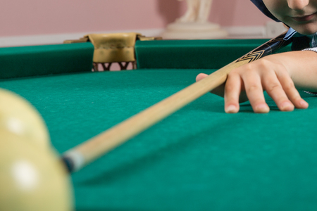 Russian billiard. Man playing billiard. Player preparing to shoot, hitting the ball. focus on hand and cueの写真素材
