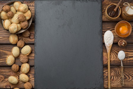 recipe. Empty stone board in the middle between the ingredients and the result. Preparation of baking nuts with condensed milk. Copy spaceの写真素材