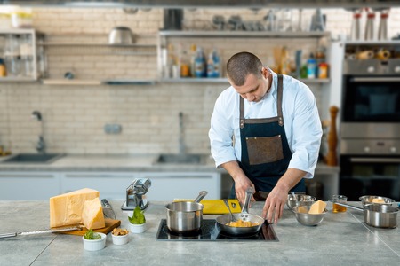 the chef fry italian food in a frying pan. kitchen interierの写真素材