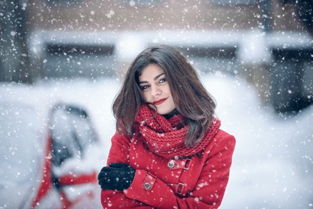 beautiful brunette woman smiling and rejoices to snow at dte city street. beautiful brunette woman smiling and rejoices to snow at dte city streetの写真素材