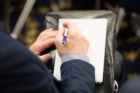 Male hand writing plans in a notepad. Work planning. Making important decisions, projects. Arrangement and conferenceの写真素材