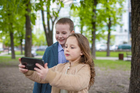 Two little kids taking selfie outdoor. Love friendship fun concept. Best friends forever. Small adultsの写真素材