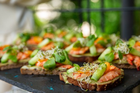 Appetizer canape with shrimp and cucumber on plate on table in the restaurant. close upの写真素材