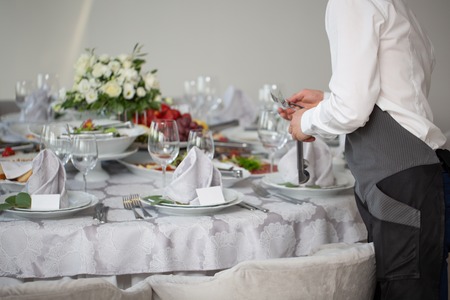 Restaurant waiter serving table with food. Wedding tableの写真素材