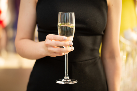 woman holding glass of champagne and toasting, happy festive moment, luxury celebration conceptの写真素材