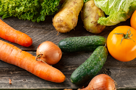 Composition with assorted raw organic vegetables on broun wooden backgroundの写真素材