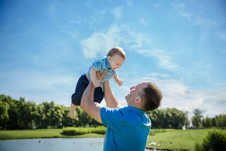 Father throwing his little son up in the air. Family time together. Happy little boy having fun with his dadの写真素材