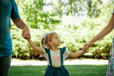 Happy young family having fun outside in spring natureの写真素材