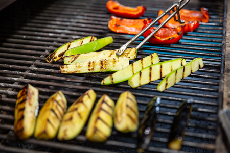 delicious vegetables grilling in open grill, outdoor kitchen. food festival in city. tasty food peppers zucchini roasting on basket, food-court. summer picnicの写真素材