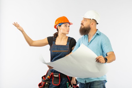 A male architect or engineer meeting with a building woman contractor on white background. The...