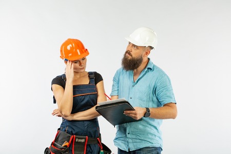 A male architect or engineer meeting with a building woman contractor on white background. The...