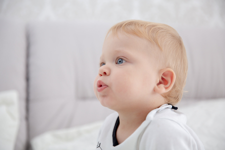 Playful little boy wearing blue pyjamas in bedof parentsの写真素材