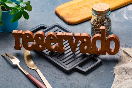 Table setting with RESERVED sign in restaurant. Reservado