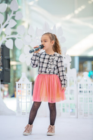 Kyiv, Ukraine March 03.2019. UKFW. Ukrainian Kids Fashion Day. Girl holds microphone in her hand while performing song at a concertのeditorial素材