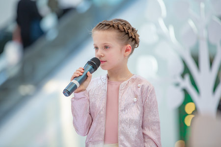 Kyiv, Ukraine March 03.2019. UKFW. Ukrainian Kids Fashion Day. Girl holds microphone in her hand while performing song at a concertのeditorial素材