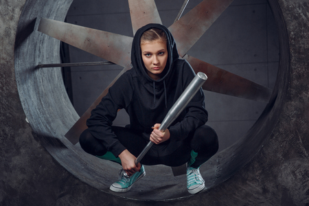 A young person with a metal bat against the propeller.の写真素材