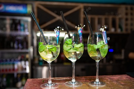 Fresh mojito cocktail in three glasses on barの写真素材