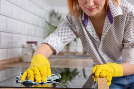 Pretty woman doing her house chores at home. housewife wipe the hob