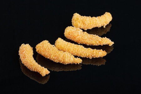 Fried Shrimps tempura in black plate on dark concrete surfaceの写真素材