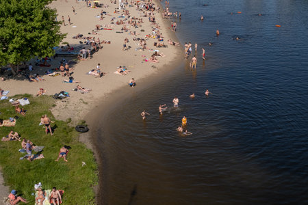 KIEV - UKRAINE - June 2019: hot weather, 35 degrees, residents spend time on the beach in Hydropark on the banks of the Dnieper. cityscape. people relax on the beach in the cityのeditorial素材
