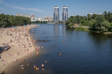 KIEV - UKRAINE - June 2019: hot weather, 35 degrees, residents spend time on the beach in Hydropark on the banks of the Dnieper. cityscape. people relax on the beach in the cityのeditorial素材
