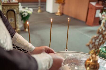 Orthodox church priest putting lights candles and prays, Orthodox church.の写真素材