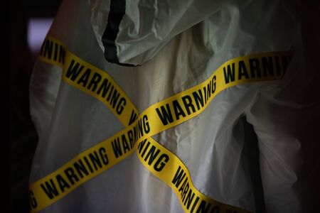 Yellow ribbon with the inscription warning at the raincoat.の写真素材