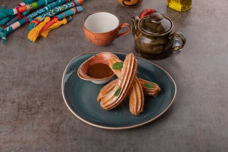 Churros with sugar and chocolate sauce, mint.の写真素材