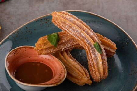 Churros with sugar and chocolate sauce, mint. traditional spanish dessertの写真素材