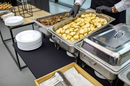 banquet table with chafing dish heaters. Many buffet heated trays at the cateringの写真素材