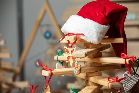 Santa Claus hat on wooden xmas tree. Merry christmas card. Winter holiday theme. Happy New Year....
