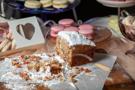 Raisin cake, dusted with icing sugar. Cupcake with raisins on a wooden board on the background of...