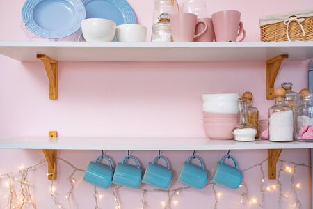 Christmas interior decoration picture of kitchen shelf with cups can and garland indoor background view. Space for textの写真素材