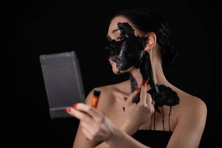 Woman doing black makeup for Halloween.の写真素材