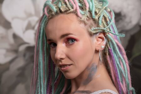 Portrait of woman with bright colors dreadlocks. woman on flower backgroundの写真素材