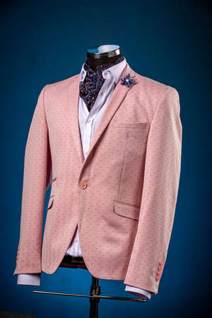 Male luxurious classic suit checkered pink jacket on dummy or mannequin on blueの写真素材