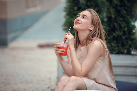 Outdoor fashion beauty portrait of glamour elegant lady, amazing long hairs, drinking tasty cold cocktails, city cafe terrace, travel, joy, relax.の写真素材