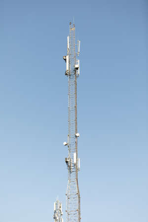 Mast or tower for mobile phone communication in bright sunshine and blue sky. Relay tower internet...