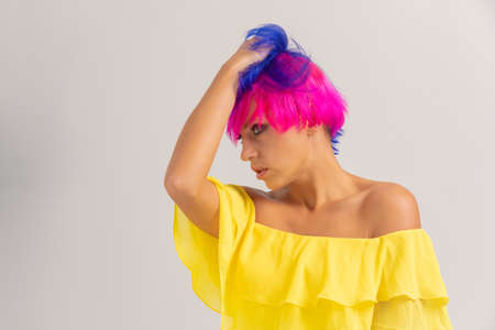 Portrait of a woman with bright colored hair, blue and pink haircut. girl with short hair dressed to...