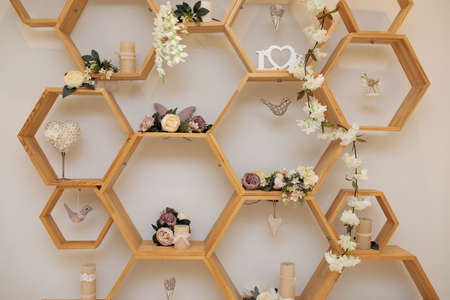 Fragement of interior decoration. Wall with wooden honeycomb shelves. Trendy design. wedding decorationsの写真素材