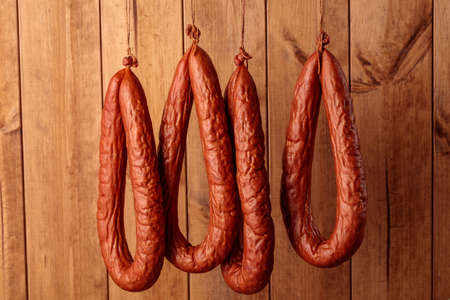 tied fermented sausages rings hanging on rope.の写真素材