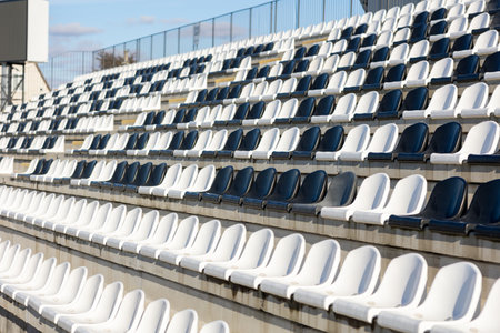Empty black and white Plastic Chairs at the spotr Stadium. side view