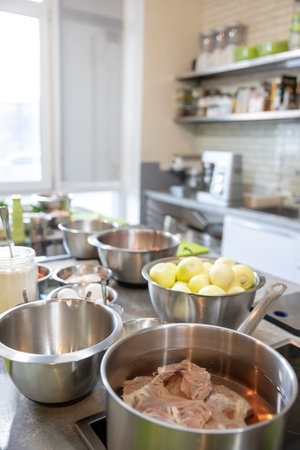 pan on the stove with meat in kitchen interior home. food preparation processの写真素材