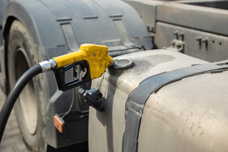 filthy semi-truck on gas station. truck fueling. Hose inserted into the tank
