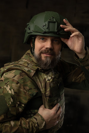 Portrait of a soldier in Combat Uniform wearing at helmet and body armor. military man looking at the camera. Studio portrait on a black background.の写真素材