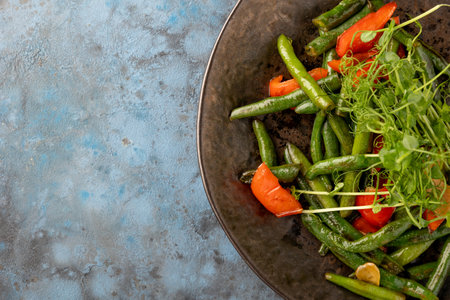 Garnish of asparagus, bell pepper, microgreens on blue grey background. Top view.