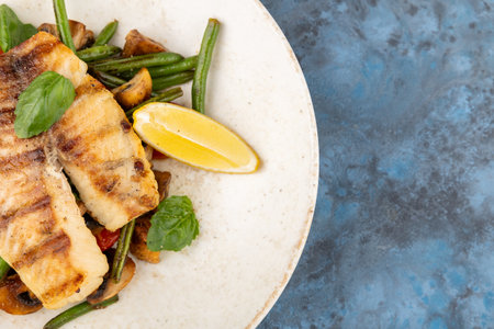 grilled salmon with asparagus, pea, yellow peppers, carrots and spring onions on plateの写真素材